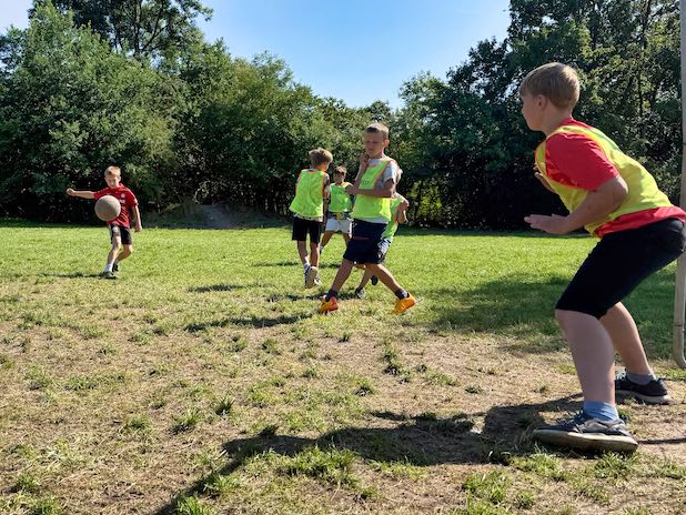 Ein Mädchen, dass in einem Planschbecken mit einem aufblasbaren Stier kämpft.